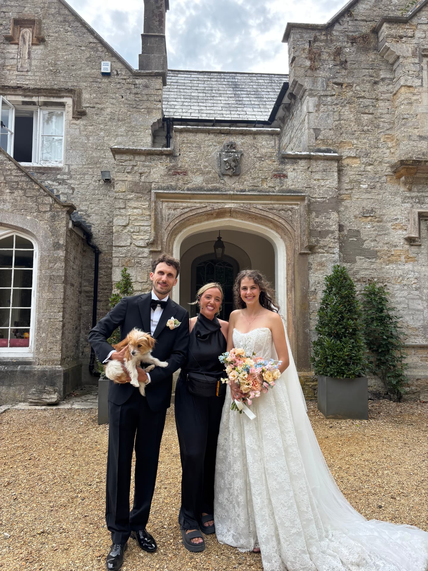 Harriet with a couple on their wedding day outside a Dorset wedding venue